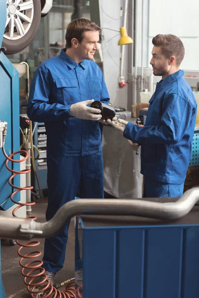 Sauberer Mechaniker reicht seinem Kollegen ein Detail — Stockfoto