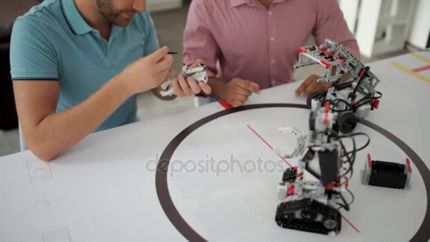 Equipo de dos profesionales charlando sobre robótica — Vídeo de stock