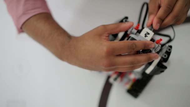 Вид сверху на мужские руки, создающие роботов — стоковое видео