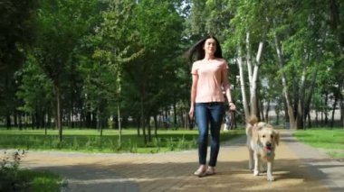 Köpeğiyle yürüyen neşeli güzel kadın