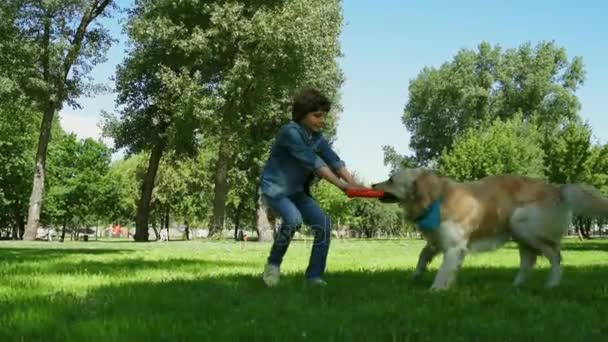 Alegre niño disfrutando del tiempo con su perro — Vídeo de stock