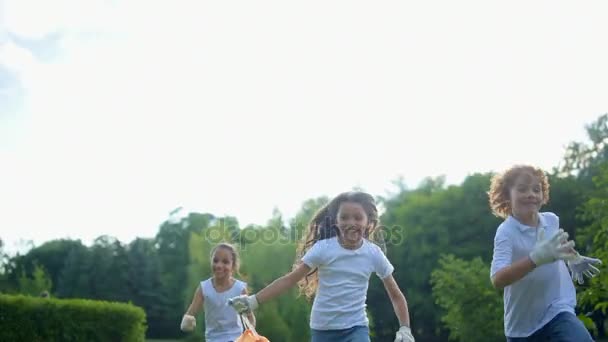 Radiant young environmentalists running with excitement after cleaning in park — Stock Video