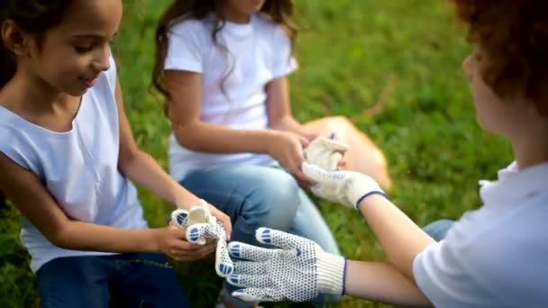 Niño consciente entregando guantes para compañeras voluntarias — Vídeos de Stock