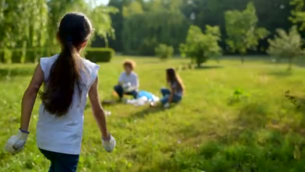 Little brunette lady running to voluntary friends and helping them — Stock Video