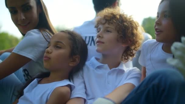 Kinder und Freiwillige entspannen sich nach dem Putzen im Freien — Stockvideo