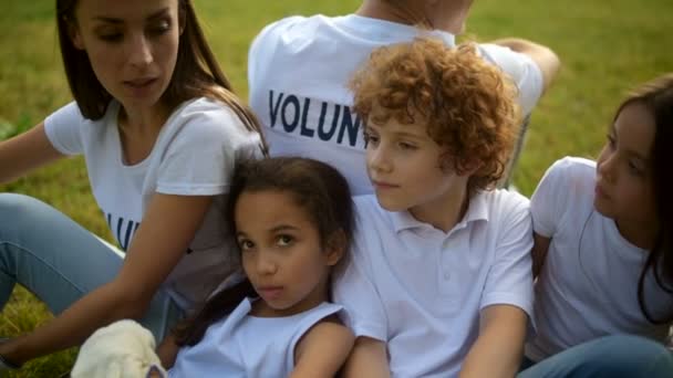 Crianças encantadoras discutindo seu dia com voluntários — Vídeo de Stock