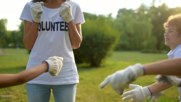 Entzückende Kinder umarmen weibliche Freiwillige im Freien — Stockvideo