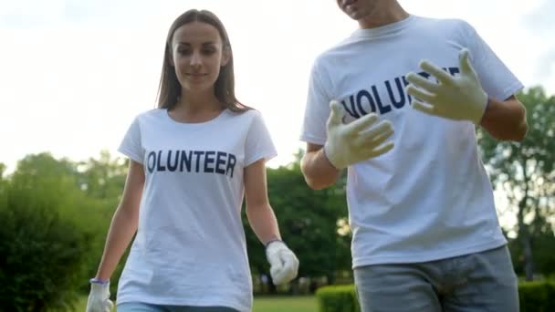 Веселые добровольцы, отдыхающие и рассказывающие о своей работе — стоковое видео