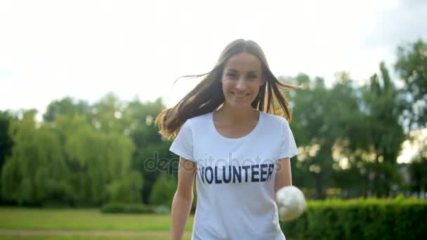 Des bénévoles joyeux et des enfants courent et sourient devant la caméra — Video