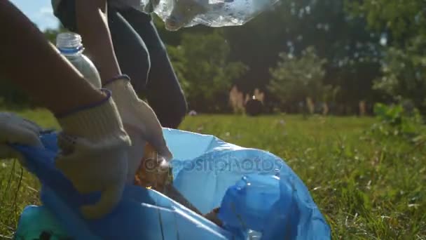 Close up of young environmentalists cleaning up trash outdoors — Stock Video