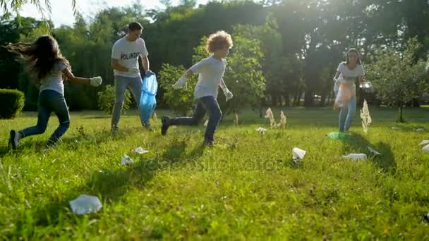 Заботливые дети помогают волонтерам собирать мусор в парке — стоковое видео