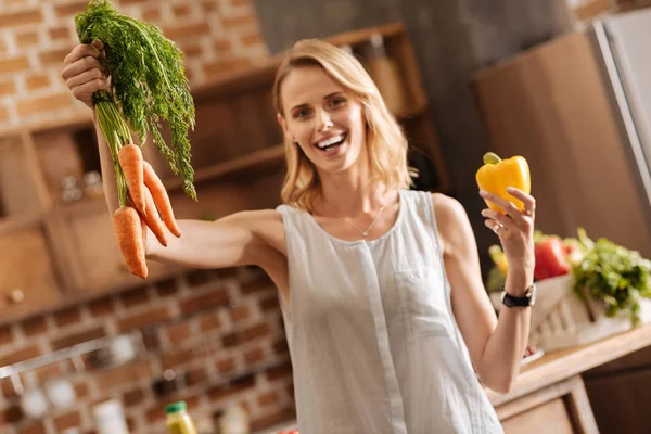 Dinamikus élénk hölgy gazdaság néhány zöldségeket a kezében — Stock Fotó