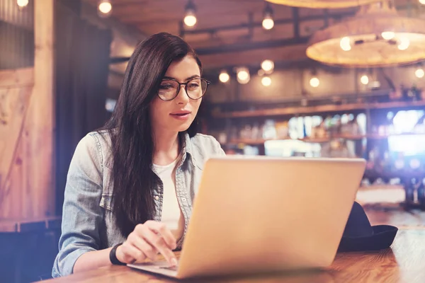 Concentrated longhaired woman working with laptop — Stock Photo, Image