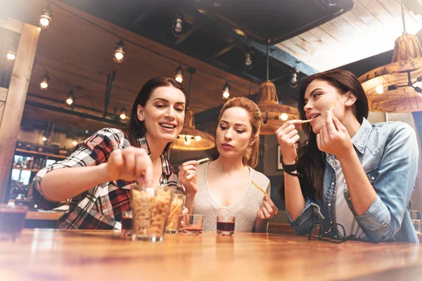 Chicas atractivas que comen bocadillos en el pub — Foto de Stock
