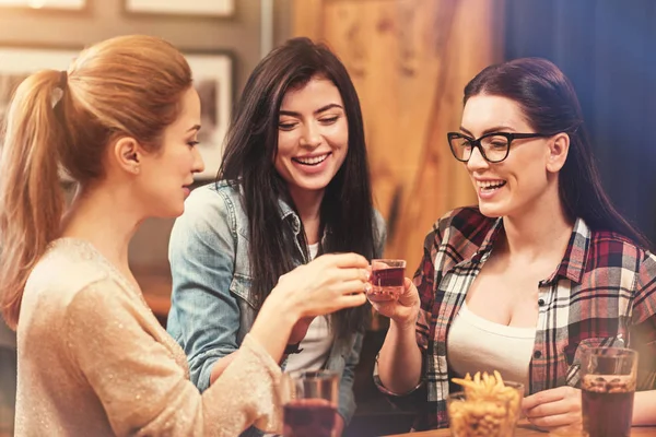 Счастливые девушки касаются стаканов с напитками — стоковое фото