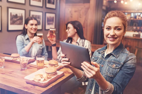 Persona femenina encantada sosteniendo su tableta — Foto de Stock