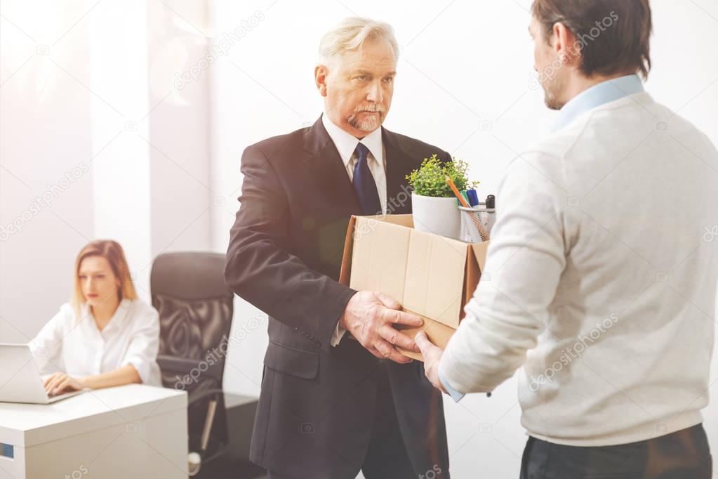 Determined enterprising executive asking his employee leaving the office