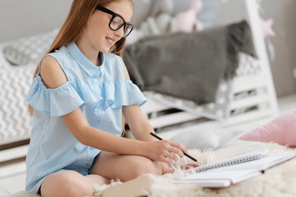 Feliz colegiala escribiendo en cuaderno — Foto de Stock