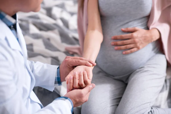 Jovem grávida segurando a mão na barriga — Fotografia de Stock