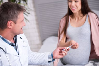 Memnun doktor hastası için termometre veren