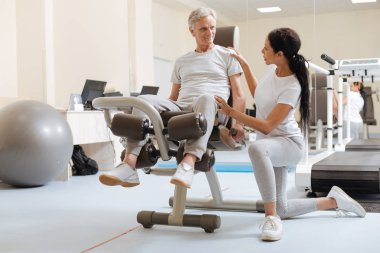 Simülatör üzerinde oturan gri saçlı adam