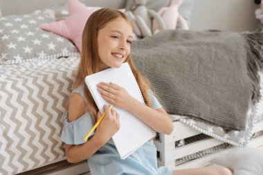 Parlak kız defter çizerken kucaklayan