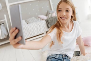 Selfies yatak odasında alarak heyecanlı küçük kız