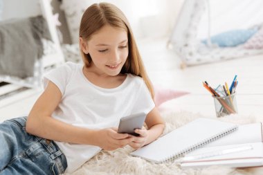 Sevimli kız yatak odasında telefon üzerinde çalışıyor