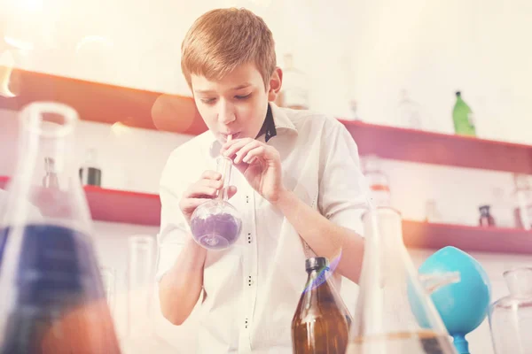 Zainteresowany wynikiem nastolatek dmuchanie do butelki — Zdjęcie stockowe