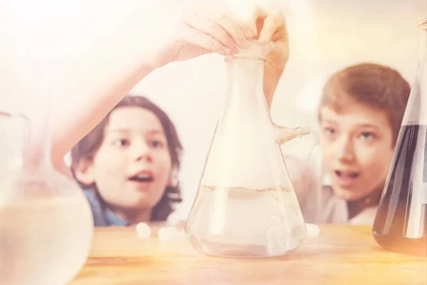 Surprised boys putting their fingers on the top of flask — Stock Photo, Image