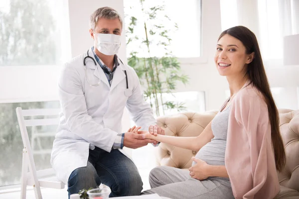 Delighted pregnant woman posing on camera