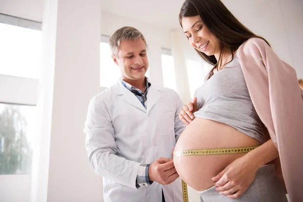 Foto de perfil del embarazo que mirando su vientre —  Fotos de Stock