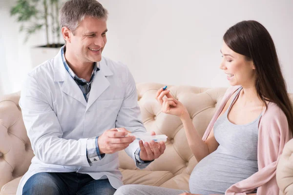 Delighted brunette choosing necessary tablet — Stock Photo, Image