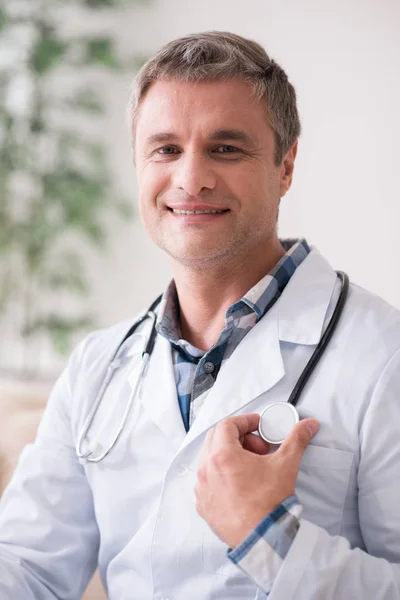 Trabajador médico competente tocando su estetoscopio —  Fotos de Stock