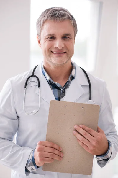 Positive delighted family doctor being at his workplace — Stock Photo, Image