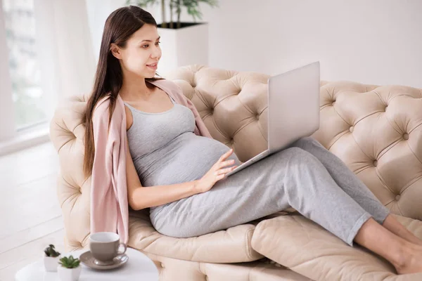 Serious brunette using her laptop — Stock Photo, Image