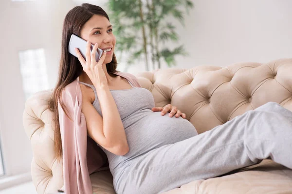 Positive pregnant girl lying on the coach — Stock Photo, Image