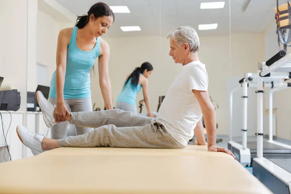 Serious senior pensioner sitting in semi position — Stock Photo, Image