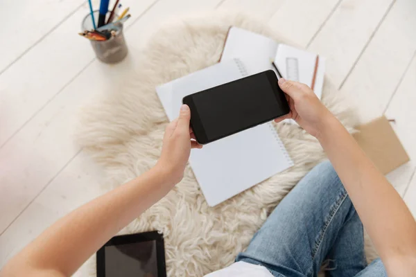 Bovenaanzicht op smartphone in handen van schoolmeisje — Stockfoto