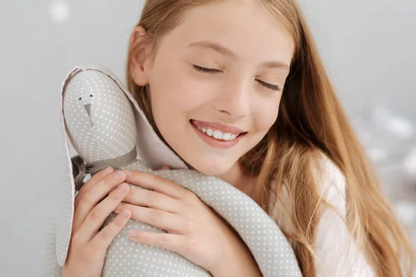 Jovem feliz abraçando brinquedo favorito — Fotografia de Stock