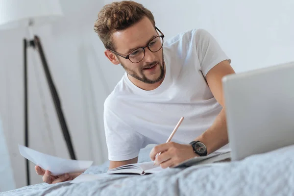 Positiv glad man skriva några punkter i anteckningsboken — Stockfoto