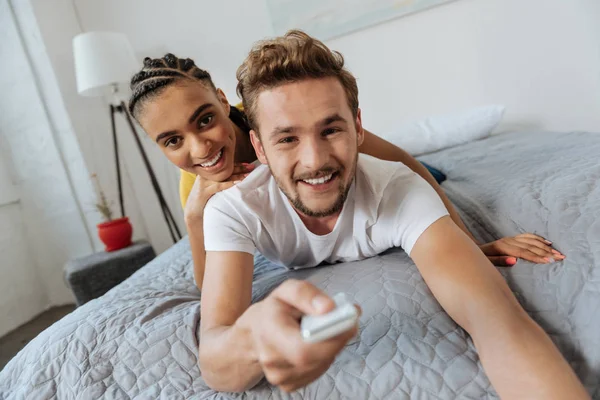 Glada par använder konsolen medan du väljer kanal — Stockfoto