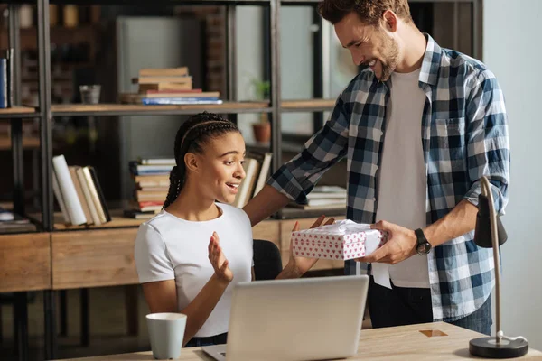 Mujer sorprendida mirando caja con presente — Foto de Stock