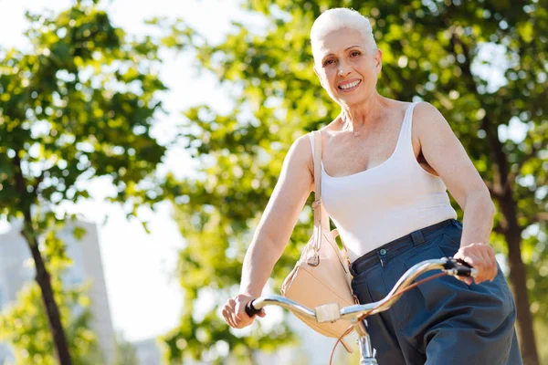 Снимок пожилой женщины, катающейся на велосипеде на открытом воздухе — стоковое фото