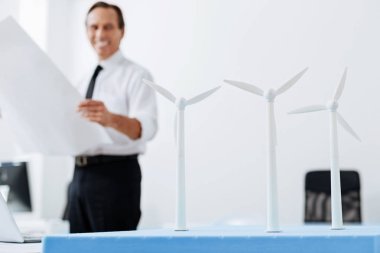 Neşeli mühendis de rüzgar türbinleri bakarken gülümseyen