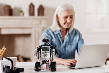 Oturma odasının ışık odasında memnun yaşlı kadın