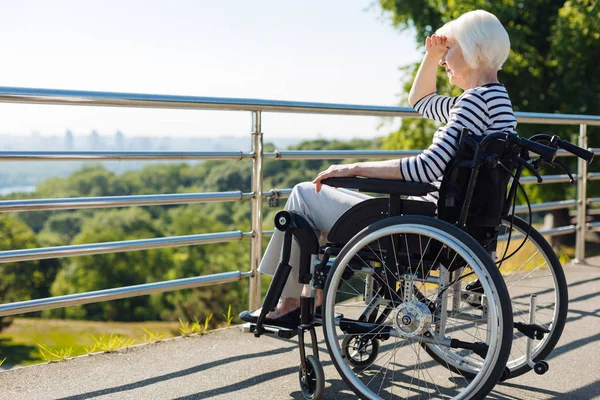 Довольно вдохновлённая пожилая женщина, сидящая в инвалидном кресле — стоковое фото