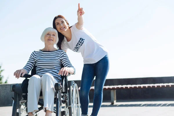 Glad nyfiken volontär pekar fingret på något — Stockfoto