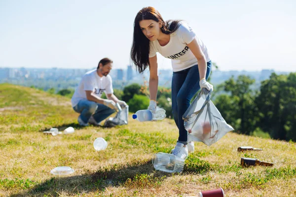 Активная восхитительная женщина чистит газон — стоковое фото
