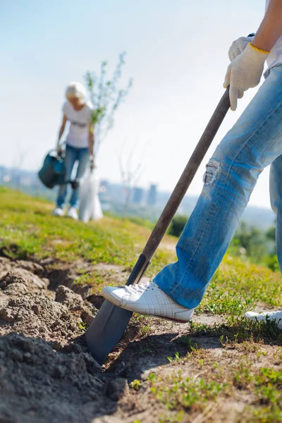 Hombre trabajador fuerte cavando agujeros para nuevas plantas — Foto de Stock